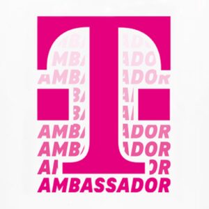 AMBASSADOR T-SHIRT WEISS mit einem auffälligen magentafarbenen "T" in der Mitte, überlagert von einem sich wiederholenden magentafarbenen "AMBASSADOR"-Text im Hintergrund für einen markanten, modernen Look.