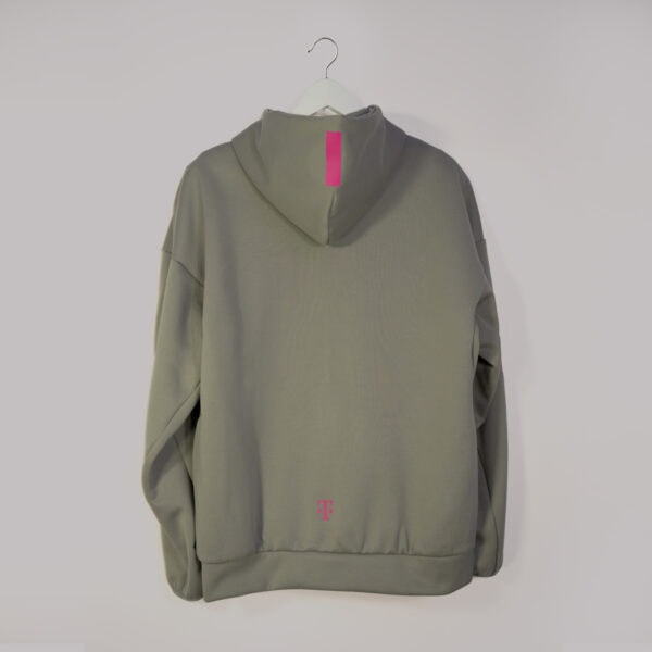 The ADIDAS T ZIP JACKET UNISEX in the color clay hangs on a white hanger against a white background. It features a small T-shaped logo in magenta on the lower back and a vertical stripe in magenta on the hood, reminiscent of the classic Adidas zipper jacket style.