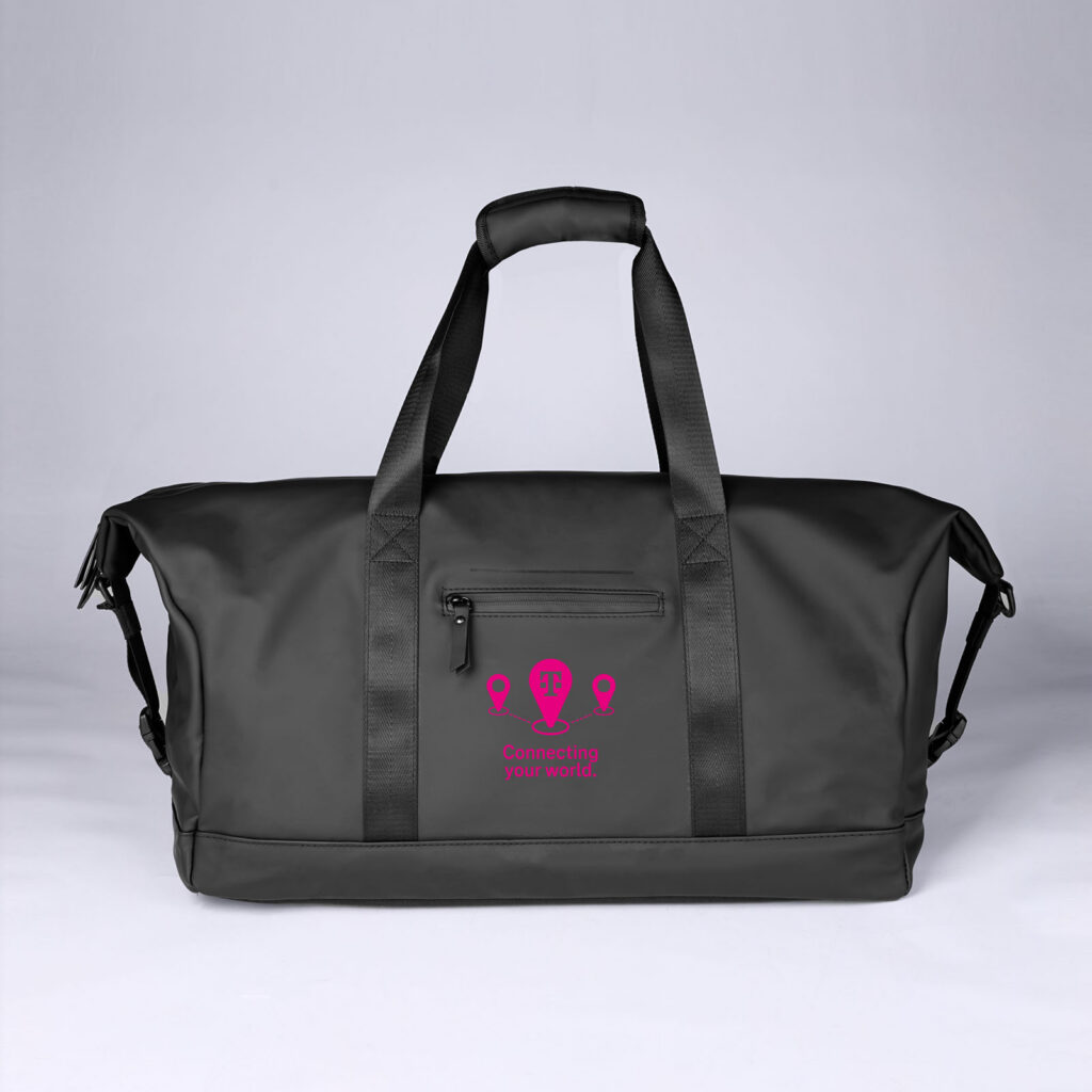 Eine große schwarze Reisetasche mit schwarzen Tragegriffen und einem rosa Logo sowie dem Schriftzug „Connecting your world!“ auf der Vordertasche. Die Tasche ist vor einem schlichten, hellen Hintergrund abgebildet.