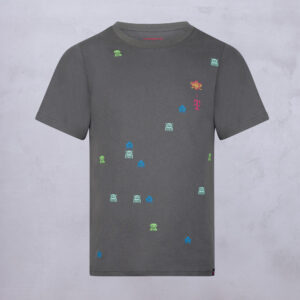 Ein graues T-Shirt, auf dessen Vorderseite bunte, kleine Pixel-Art-Motive mit Außerirdischen und Symbolen verteilt sind. Das Shirt wird vor einem hellgrauen Hintergrund gezeigt.