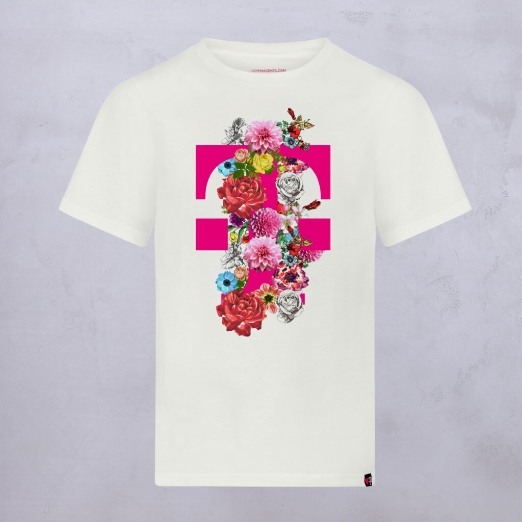 Ein weißes T-Shirt mit einem auffälligen rosa Gleichheitszeichen und bunten Blumen, darunter Rosen und Gänseblümchen, die vertikal in der Mitte auf hellgrauem Hintergrund angeordnet sind.