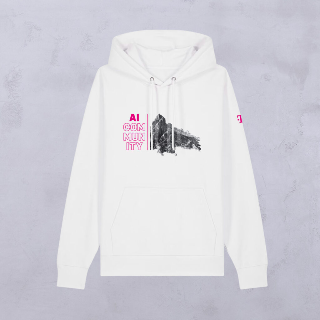 Weißer Hoodie mit „Euer Motiv“ und „AI COMMUNITY“ in rosa und weißer Schrift auf der linken Brust, neben einer schwarzen, abstrakten, bergähnlichen Grafik. Auf dem linken Ärmel befindet sich ein kleines rosa Logo. Der Hintergrund ist hellgrau.