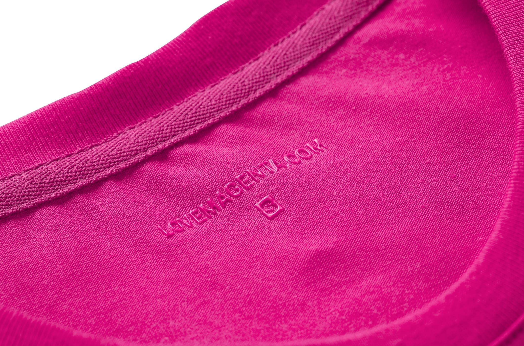Nahaufnahme eines leuchtend rosa Stoffkragens mit der Aufschrift „LAVENAYGENVA.COM“ und einem kleinen, geprägten „S“ auf der Innenseite.