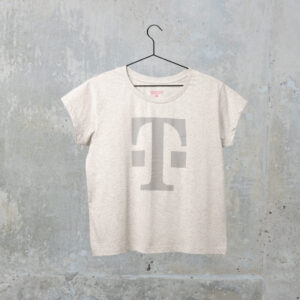 Ein graues T-Shirt mit einem großen, hellgrauen T-Logo auf der Vorderseite, das vor dem Hintergrund einer strukturierten Betonwand an einem schwarzen Kleiderbügel hängt.