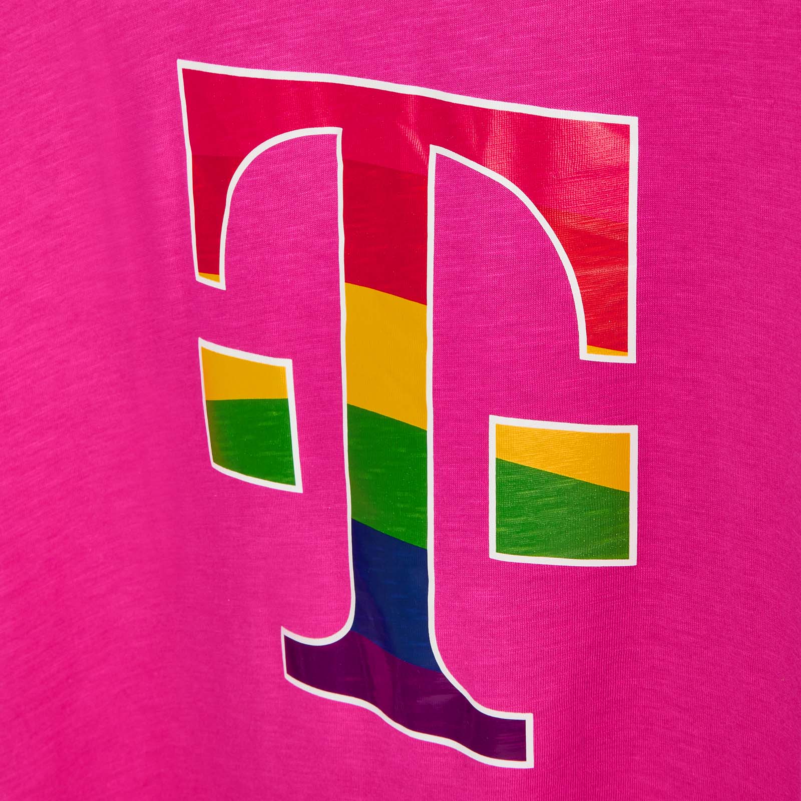 Auf einem leuchtend rosa Stoff ist ein großes T-Logo mit Regenbogenstreifen aufgedruckt, das den LGBTQ+-Stolz symbolisiert.