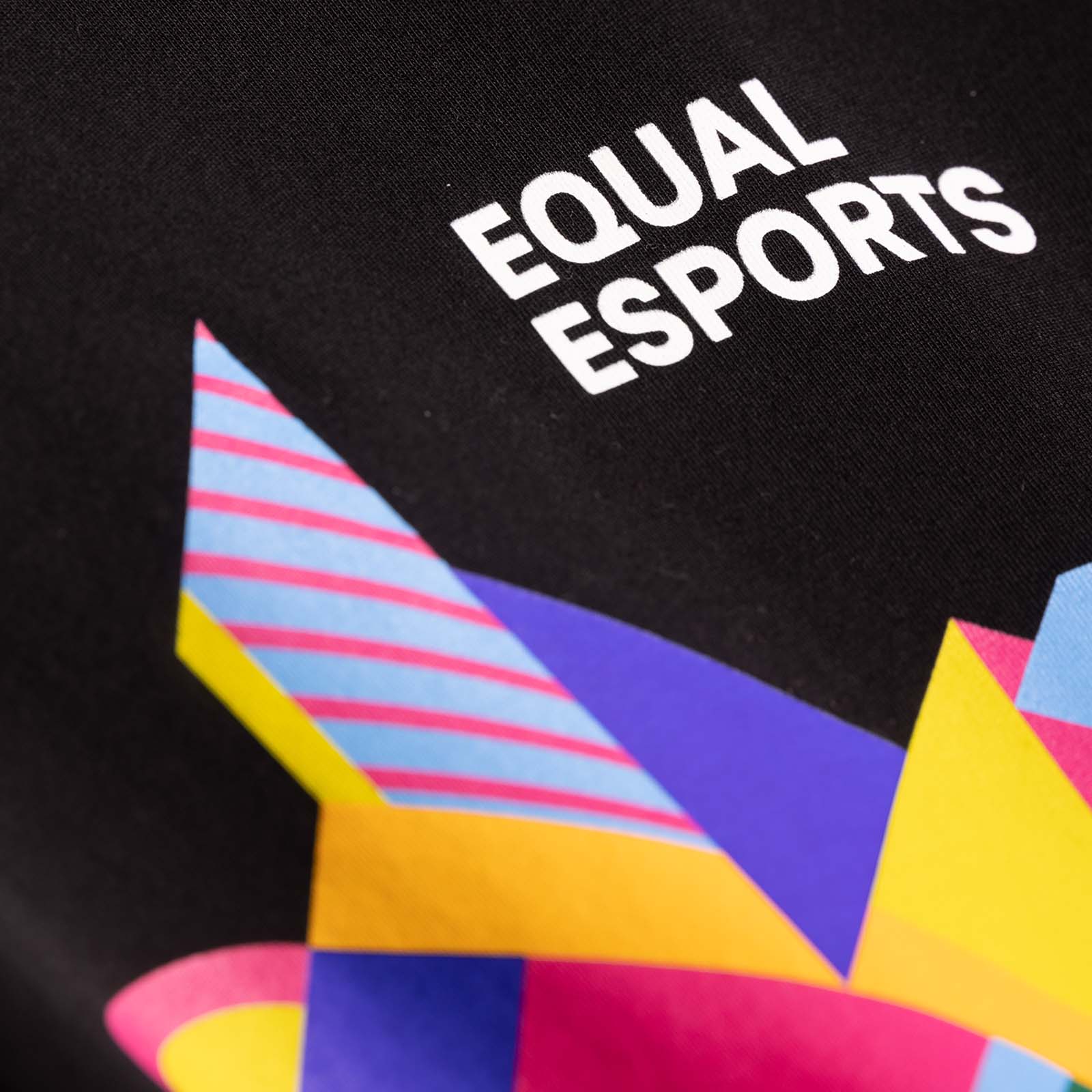 Nahaufnahme eines schwarzen Stoffes mit der Aufschrift „EQUAL ESPORTS“ in Weiß über einem bunten geometrischen Muster aus gelben, blauen, rosa und violetten Formen mit Streifen und Winkeln.