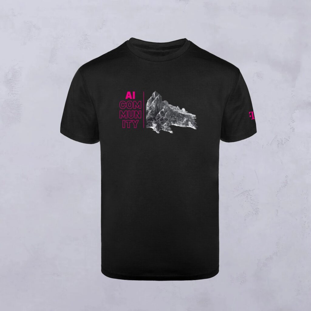 Schwarzes T-Shirt mit dem Schriftzug „AI COMMUNITY“ in Rosa auf der linken Brustseite und einer graustufigen Berggrafik auf der rechten Seite. Das Motiv wird durch ein kleines rosa Logo auf dem linken Ärmel hervorgehoben.