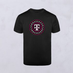 Schwarzes T-Shirt mit einem runden Logo in der Mitte. Das Logo zeigt ein weißes „T“ in einem kastanienbraunen Kreis, umrandet von dem Wort „AMBASSADOR“, das in weißen Buchstaben um den Rand herum wiederholt wird – ein Markenzeichen von Ambassador Designs.