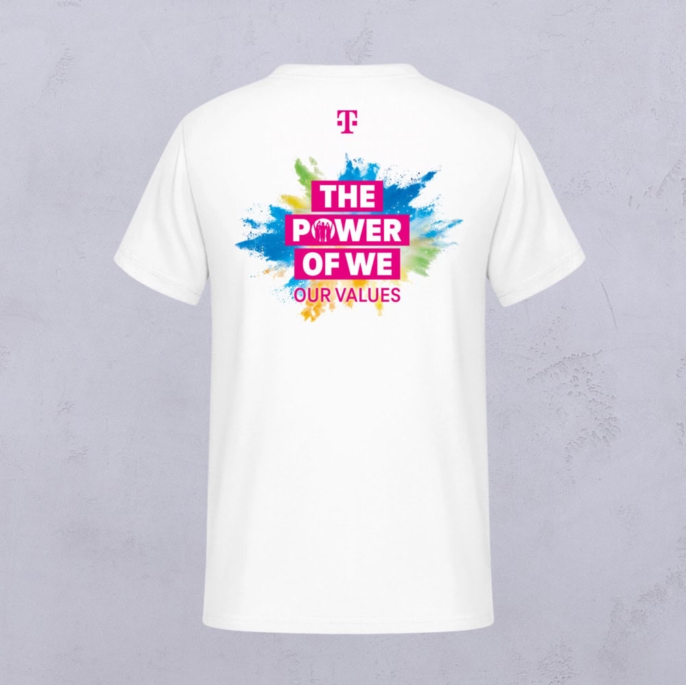 Weißes T-Shirt mit einem farbenfrohen Spritzmuster und dem Schriftzug „THE POWER OF WE OUR VALUES“ auf der Rückseite sowie einem rosa Logo im oberen Bereich – ein Beispiel für die charakteristische Kreativität von LOVE MAGENTA Studio. Das Shirt wird vor einem hellgrauen Hintergrund präsentiert.