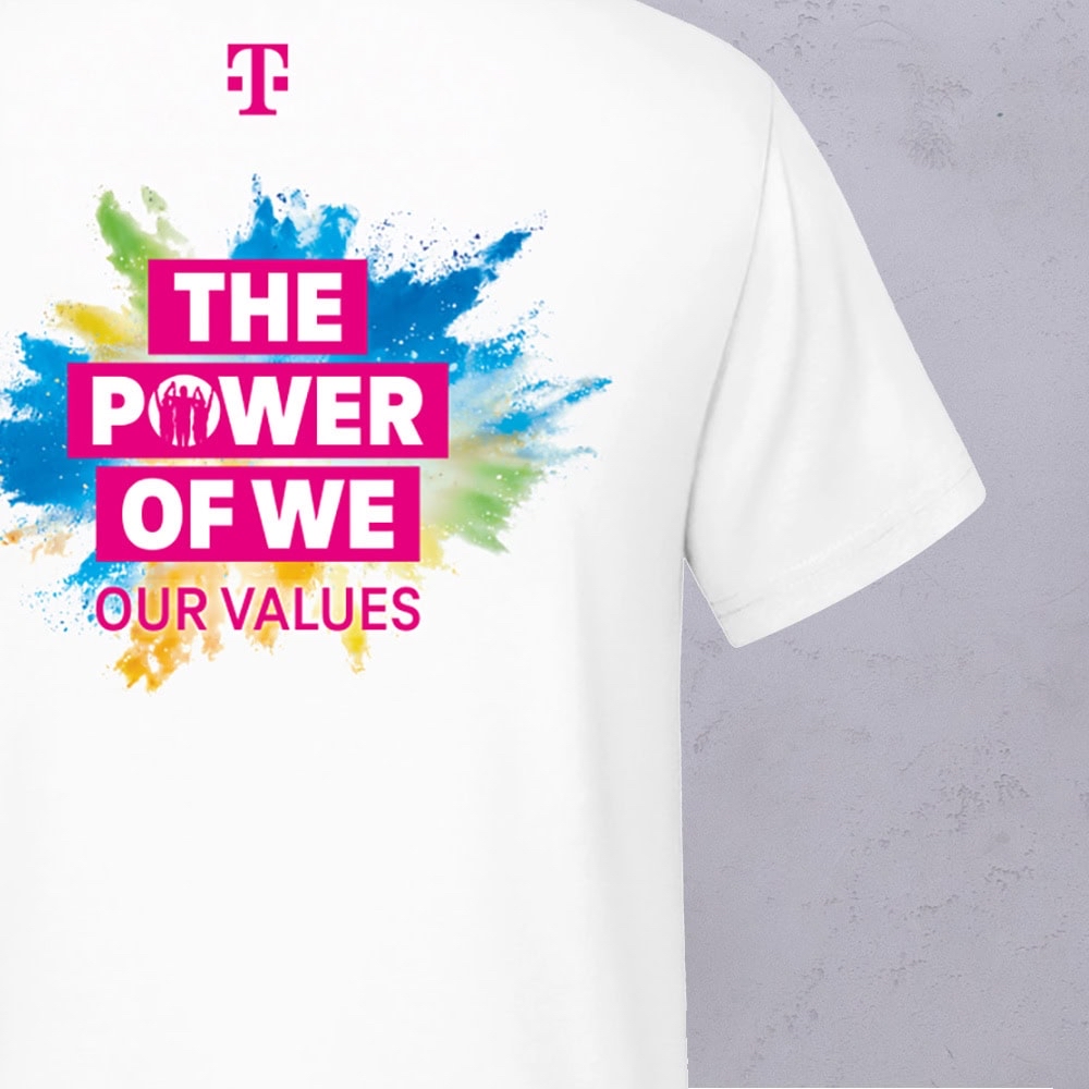 Ein weißes T-Shirt mit bunten Farbspritzern und dem Schriftzug „THE POWER OF WE OUR VALUES“ in fetten rosa Buchstaben sowie einem rosa Logo darüber – entworfen von LOVE MAGENTA Studio.