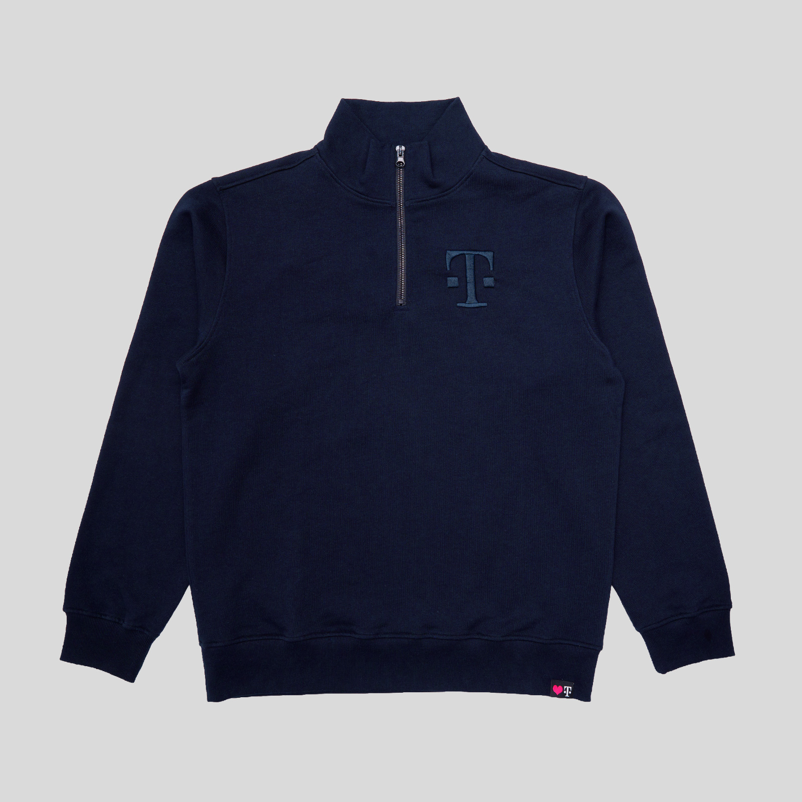 Marineblaues Sweatshirt mit Viertelreißverschluss, hohem Kragen, langen Ärmeln und einem dezenten T-Logo auf der linken Brustseite. Der Hintergrund ist einfarbig hellgrau.