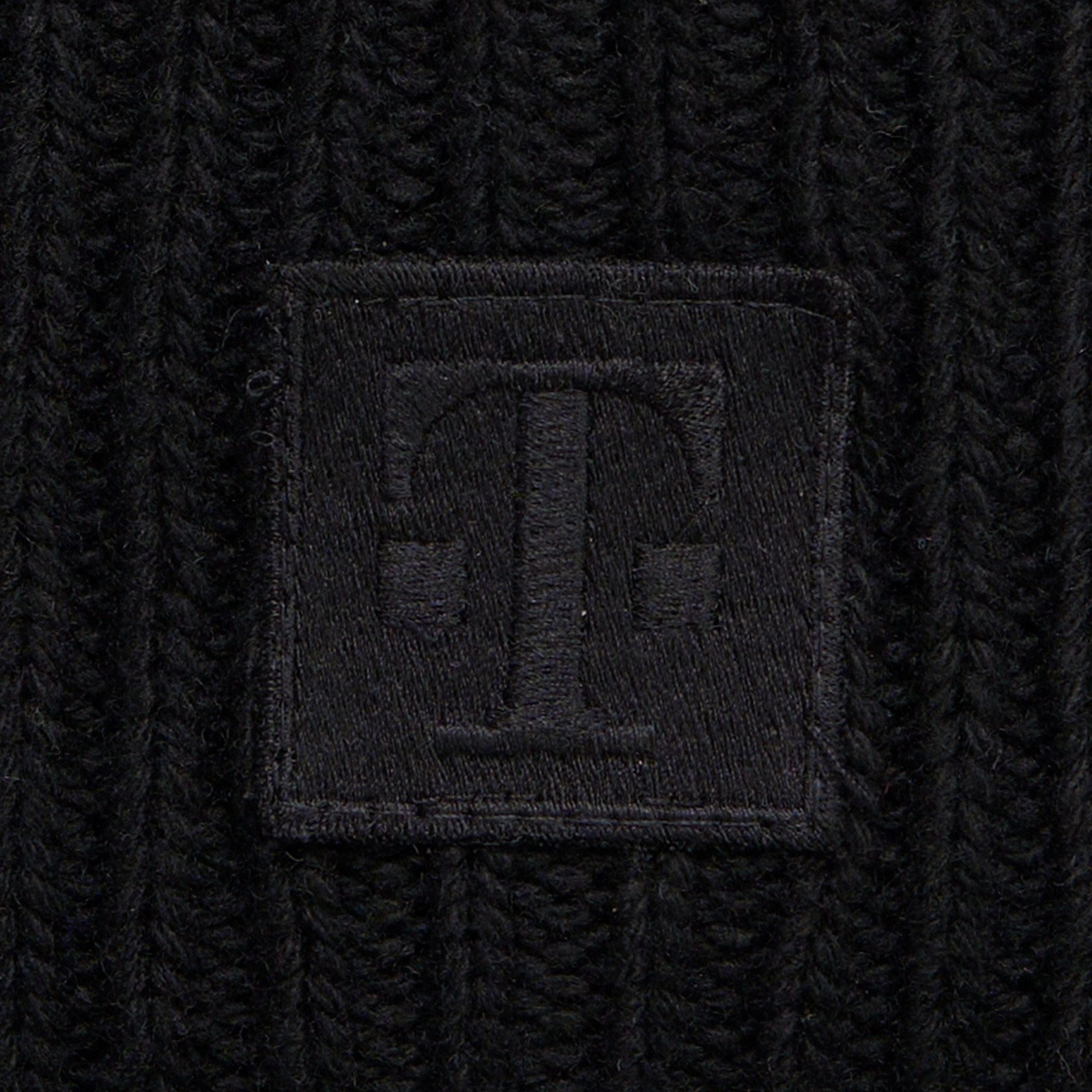 Nahaufnahme des gestickten T-Logo-Patches auf der LOGO BEANIE BLACK